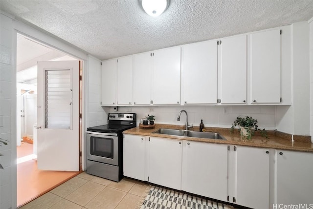 kitchen with sink, white cabinets, stainless steel range with electric stovetop, light tile patterned floors, and a textured ceiling