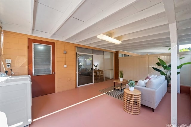 interior space featuring washer / clothes dryer, concrete flooring, and beamed ceiling