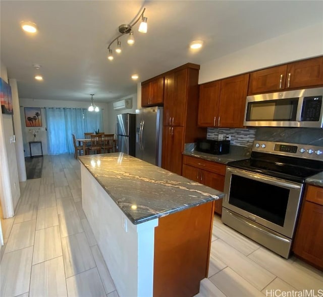 kitchen featuring dark stone countertops, decorative backsplash, a kitchen island, and appliances with stainless steel finishes