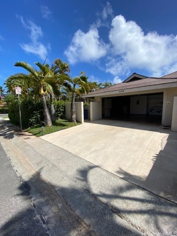 exterior space with a garage, concrete driveway, and stucco siding