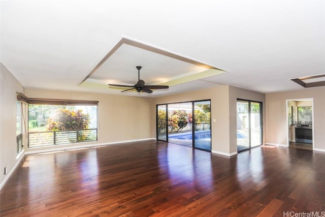 spare room featuring a ceiling fan, baseboards, a raised ceiling, and wood finished floors