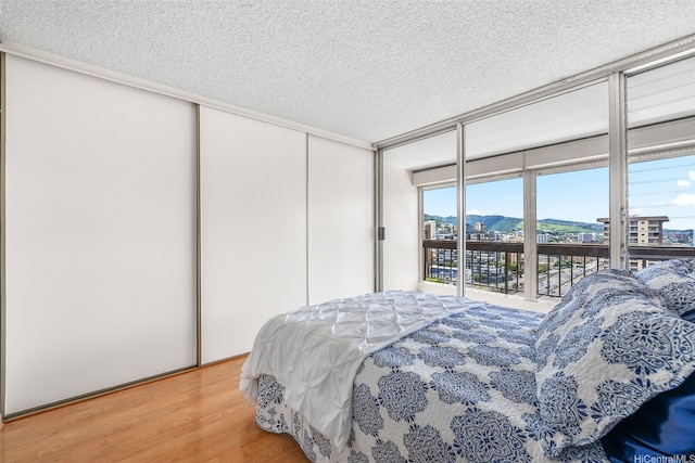775 Kinalau Pl Unit 1907, Honolulu, HI 96813 - bedroom featuring a textured ceiling, access to outside, wood finished floors, a closet, and a mountain view