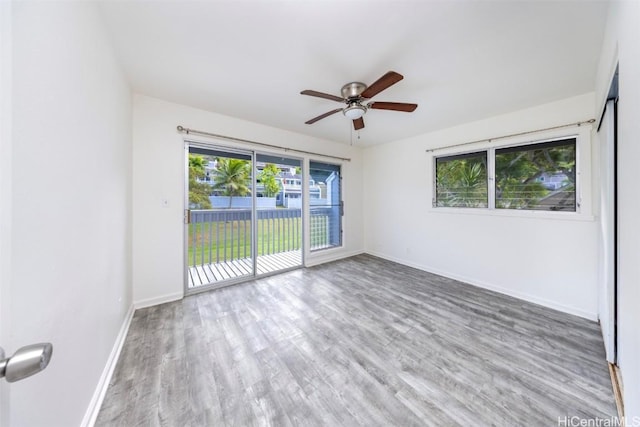 unfurnished room featuring ceiling fan, baseboards, and wood finished floors