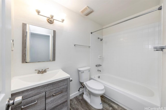 full bathroom featuring tiled shower / bath, vanity, toilet, and hardwood / wood-style floors