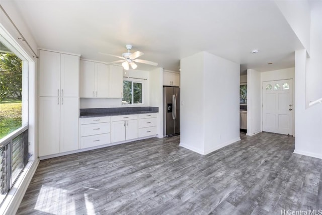 kitchen with white cabinets, hardwood / wood-style floors, stainless steel fridge, and ceiling fan