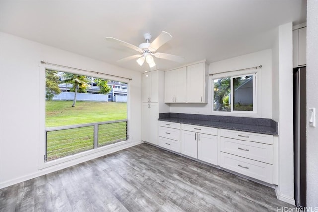 kitchen featuring white cabinetry, wood-type flooring, stainless steel fridge, and ceiling fan