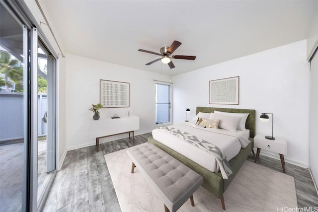 bedroom with baseboards, multiple windows, and light wood-style floors