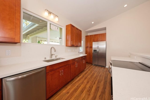 kitchen with lofted ceiling, sink, wood-type flooring, and appliances with stainless steel finishes