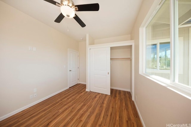 unfurnished bedroom with dark wood-type flooring, a closet, and ceiling fan