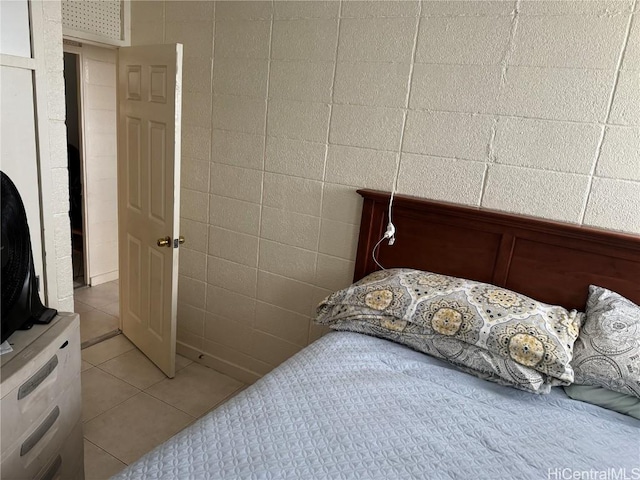 tiled bedroom featuring tile walls