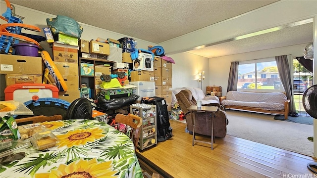 bedroom featuring hardwood / wood-style floors, access to outside, and a textured ceiling