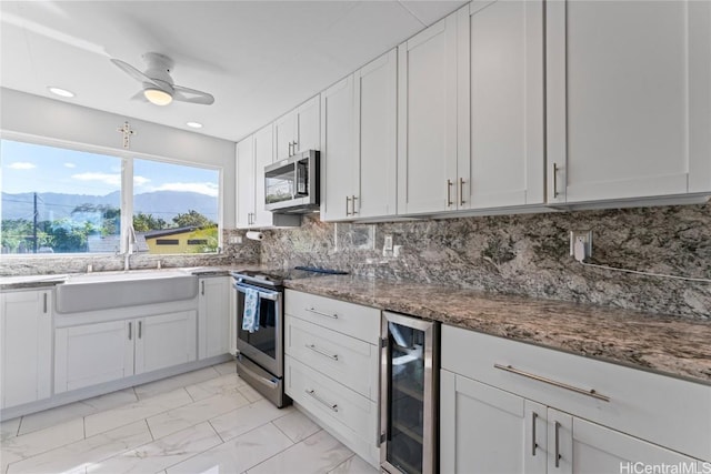 kitchen with white cabinets, appliances with stainless steel finishes, wine cooler, and a mountain view