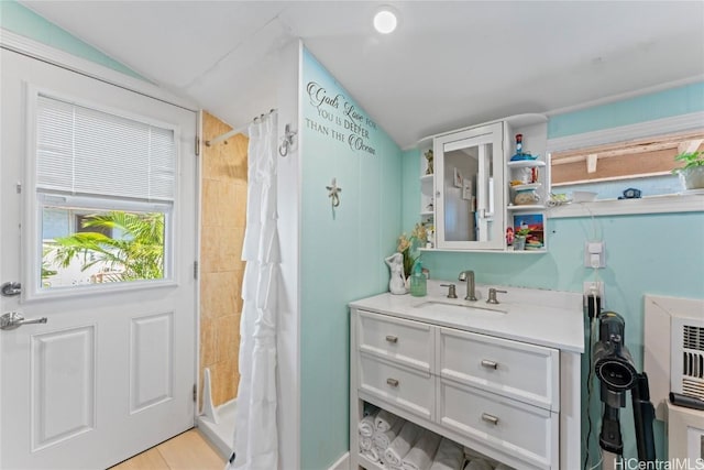 bathroom featuring vanity, lofted ceiling, and curtained shower