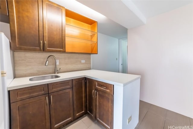 kitchen with sink, light tile patterned floors, white refrigerator, decorative backsplash, and kitchen peninsula