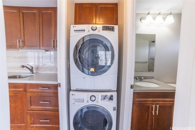 washroom with sink and stacked washer and clothes dryer