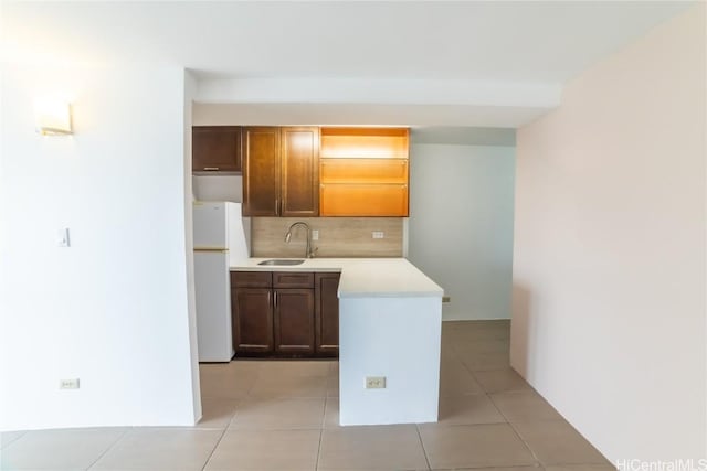 kitchen featuring light tile patterned flooring, decorative backsplash, sink, and white fridge