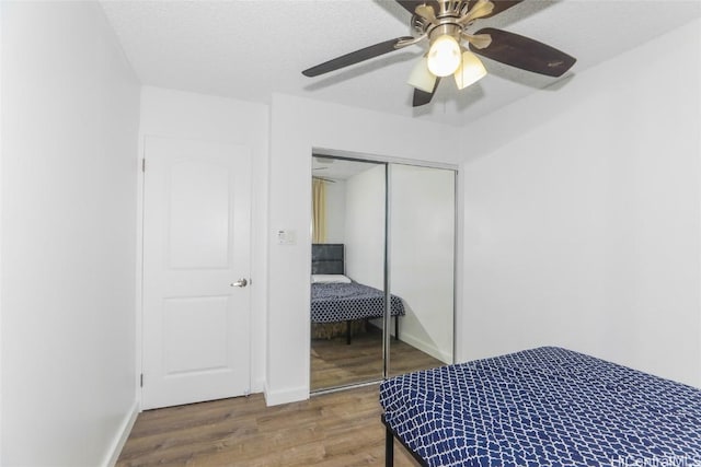 bedroom featuring hardwood / wood-style floors, a textured ceiling, ceiling fan, and a closet