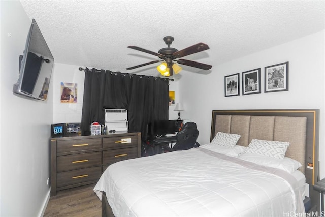 bedroom featuring ceiling fan, dark hardwood / wood-style flooring, and a textured ceiling