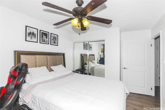 bedroom with dark wood-type flooring, a closet, and ceiling fan