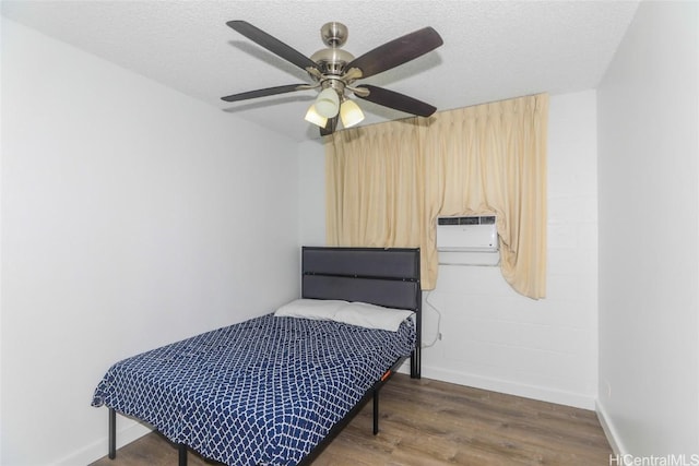 bedroom featuring ceiling fan, dark wood-type flooring, an AC wall unit, and a textured ceiling