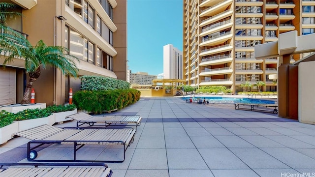 view of home's community with a pool and a patio