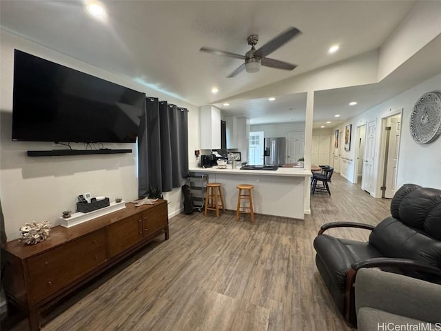 living room featuring vaulted ceiling, ceiling fan, and light hardwood / wood-style floors