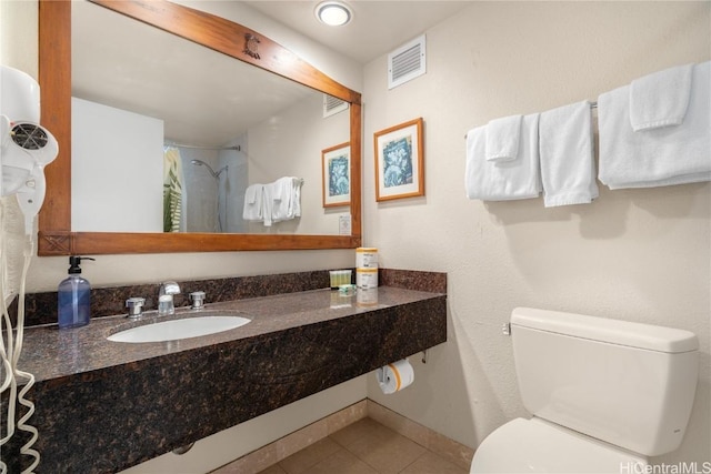 bathroom with a shower with shower curtain, tile patterned floors, toilet, and sink