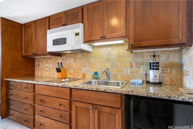 kitchen with refrigerator, sink, decorative backsplash, black electric stovetop, and light stone counters