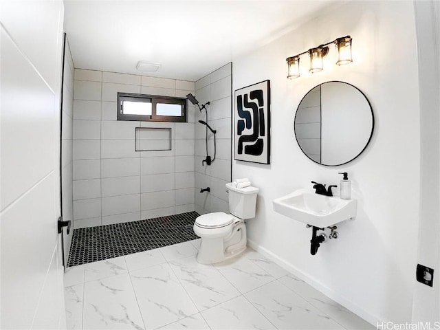 bathroom with toilet, sink, and a tile shower