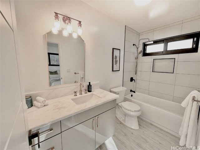 full bathroom with vanity, toilet, tiled shower / bath combo, and wood-type flooring