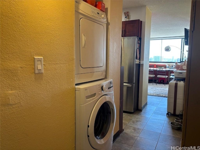 washroom with light tile patterned flooring and stacked washer and clothes dryer