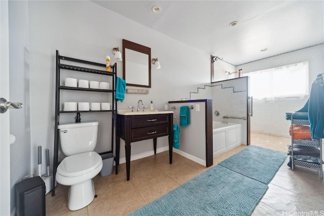 bathroom featuring vanity, toilet, tile patterned flooring, and a washtub