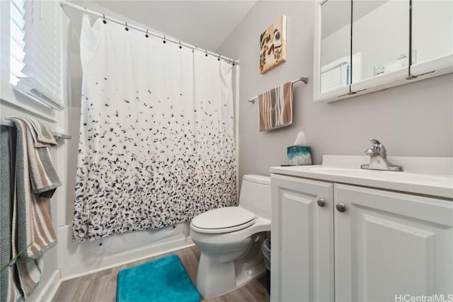 full bathroom featuring wood-type flooring, toilet, shower / bathtub combination with curtain, and vanity