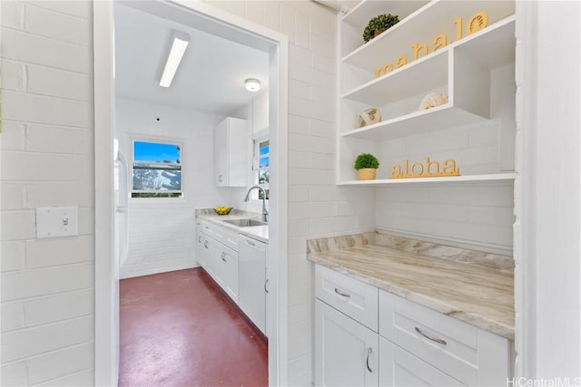 bar with dishwasher, sink, white cabinets, and light stone counters