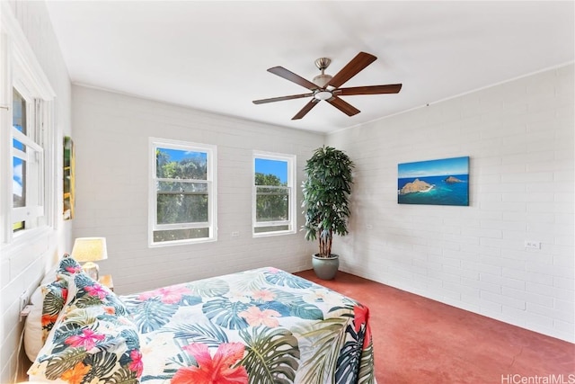 carpeted bedroom with ceiling fan and brick wall