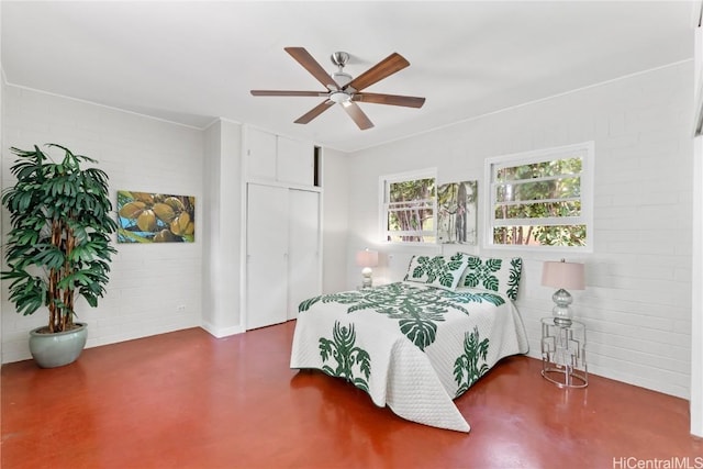 bedroom featuring concrete flooring, brick wall, ceiling fan, and a closet