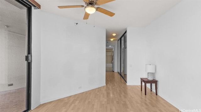 unfurnished room with ceiling fan and light wood-type flooring