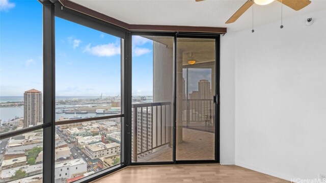 unfurnished sunroom with ceiling fan