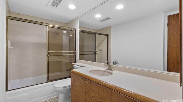 full bathroom featuring vanity, toilet, tile patterned flooring, and combined bath / shower with glass door