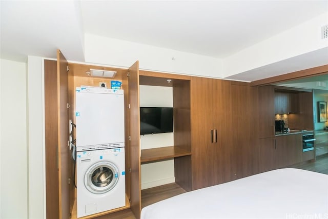 2139 Kuhio Ave Unit 1810, Honolulu, HI 96815 - washroom featuring stacked washer and clothes dryer and wood finished floors