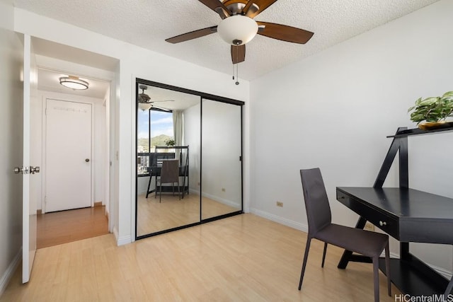 unfurnished office featuring light hardwood / wood-style floors and a textured ceiling