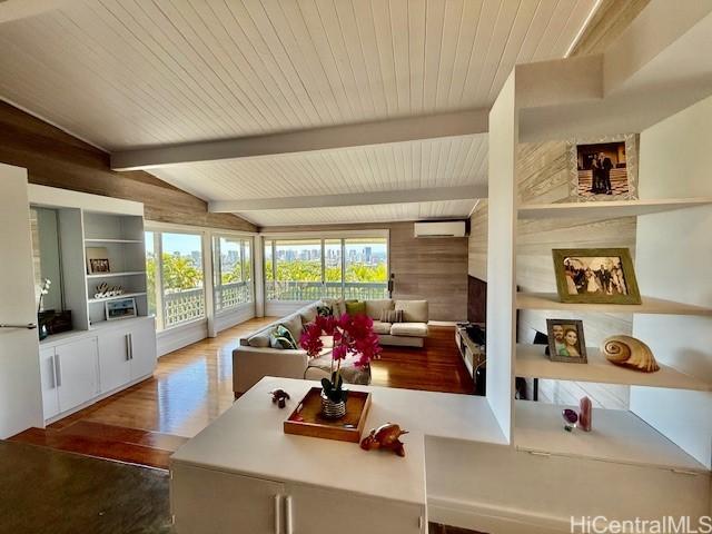 interior space featuring an AC wall unit, wood walls, lofted ceiling with beams, hardwood / wood-style flooring, and wood ceiling