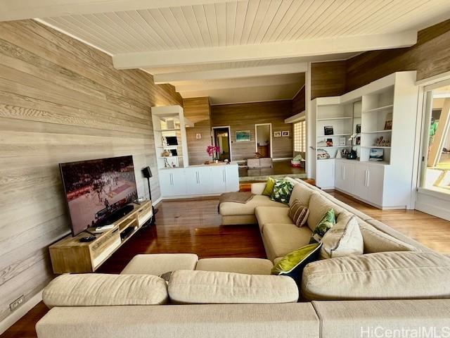 living room featuring wood ceiling, hardwood / wood-style floors, beam ceiling, and wood walls