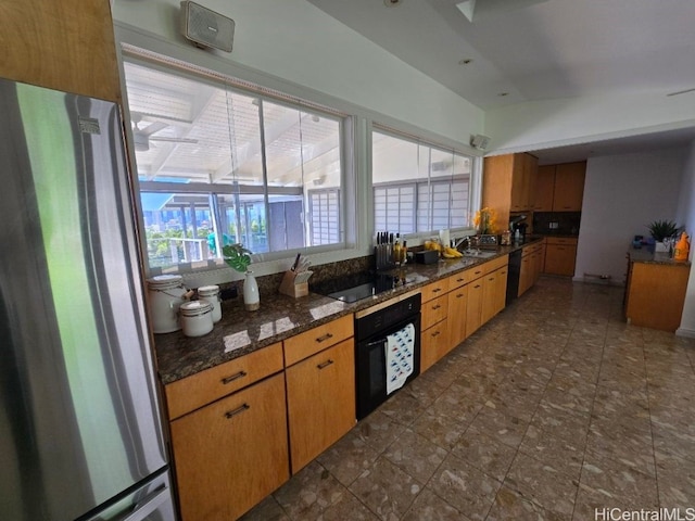 kitchen featuring sink, dark stone countertops, and black appliances