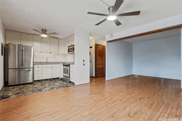 kitchen featuring a textured ceiling, ceiling fan, stainless steel appliances, light hardwood / wood-style floors, and white cabinets