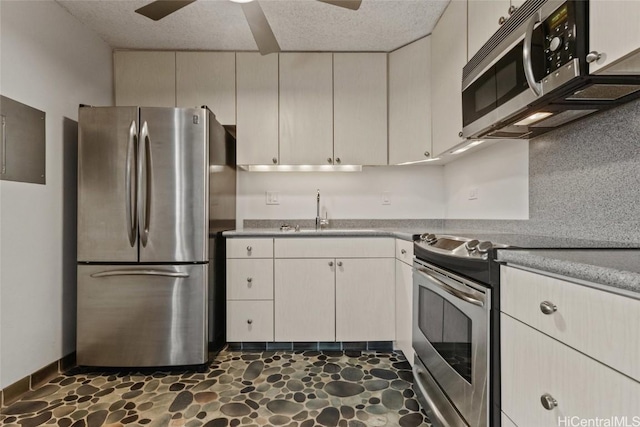 kitchen featuring sink, a textured ceiling, stainless steel appliances, and ceiling fan