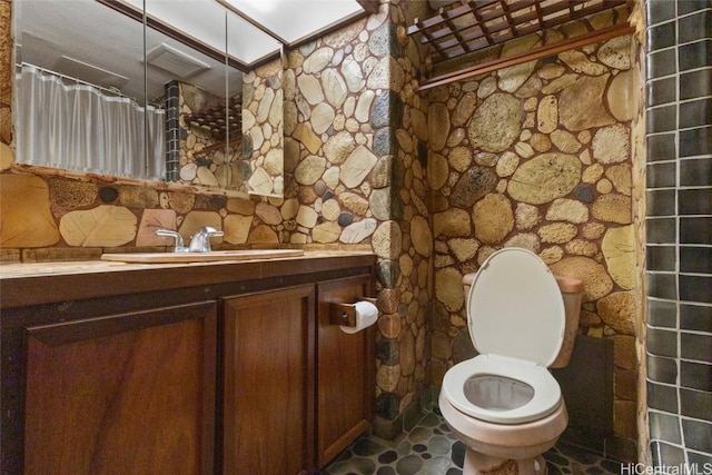 bathroom featuring vanity, walk in shower, and toilet