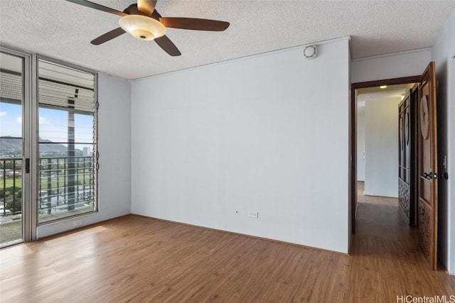 spare room with wood-type flooring, floor to ceiling windows, and a textured ceiling