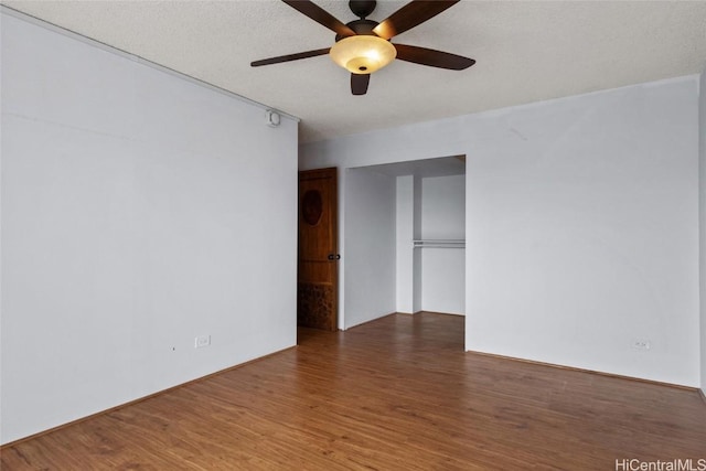 empty room featuring ceiling fan, dark hardwood / wood-style flooring, and a textured ceiling