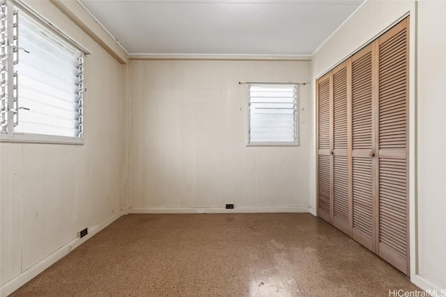 unfurnished bedroom with multiple windows and a closet